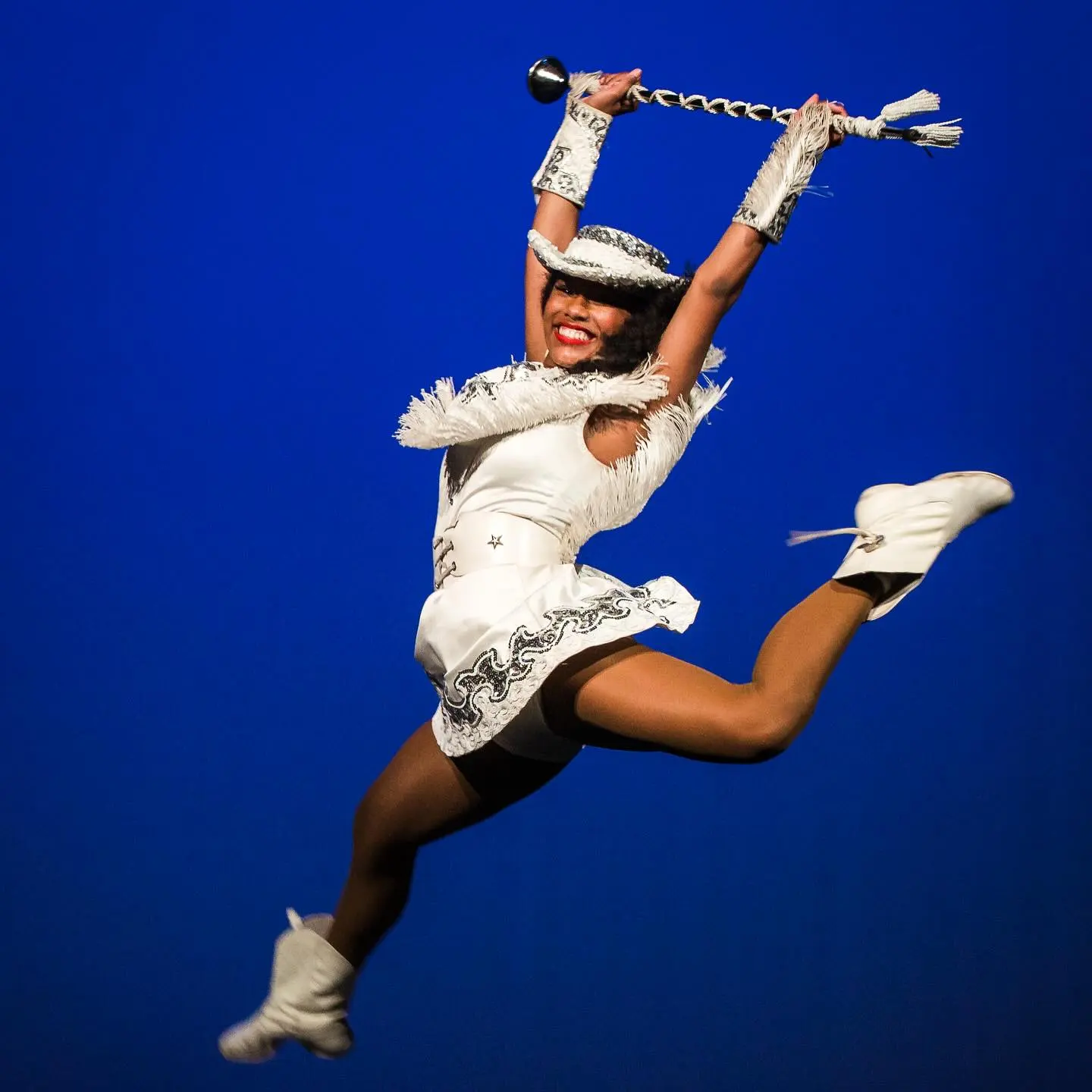 A performer in white mid-leap